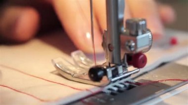 O kumaş keser ve bir makinede diker gibi bir dikiş proje üzerinde çalışan bir kadın. dikiş makinesi yakın bir bez dikiş sırasında bir makinede destekleyen bir terzi bir el kadar.