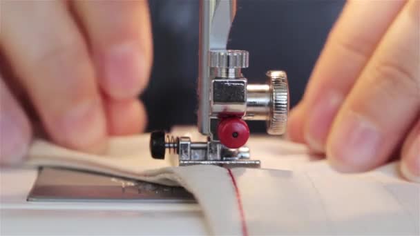 生地をカットする機械で縫うと 縫製のプロジェクトで働く女性 マシンでぬいながら布を支える仕立て屋の手をすぐミシン — ストック動画