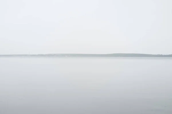  ufuk göl manzara. Ufuk manzara sahil Dağları ile. Huzurlu sakin su manzara sakin düz yüzey ile uzun pozlama ateş.