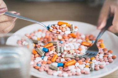 Kadın eli tabakta haplardan bahsediyor, sağlıksız beslenme konsepti 