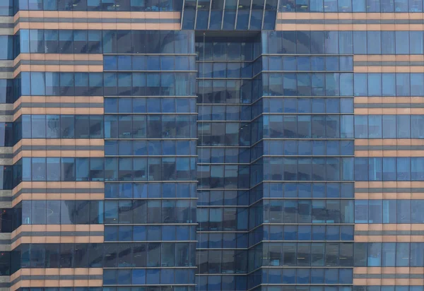 City office life. office workers light up the multiple floors office building and work overtime in the night time. glasses steel and aluminum clad modern office in Bangkok business district.