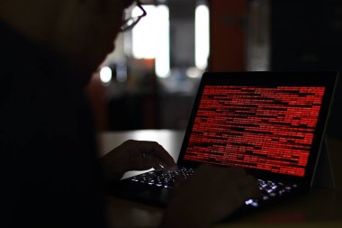 Bilgisayar suç Hacker karanlık bir odada bilgisayarda yazarak siluet. İkili kod teknolojisi üzerinde çalışıyor. ikili veri, bilgisayar suç ve ağ güvenlik kavramları.