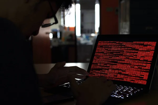 Bilgisayar suç Hacker karanlık bir odada bilgisayarda yazarak siluet. İkili kod teknolojisi üzerinde çalışıyor. ikili veri, bilgisayar suç ve ağ güvenlik kavramları.