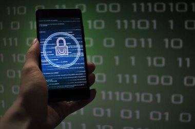 veri akışı akışında korumalı. asma kilit simgesi sembolize güvenlik ve yeşil ikili kod bilgisayar veri içinde belgili tanımlık geçmiş. cep telefonu tutan el.