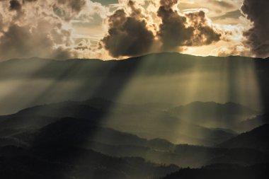 bulut ile parlayan güneş. ve dağ arasındaki kapak boşluk. dağ aralıkları çok katmanlı.