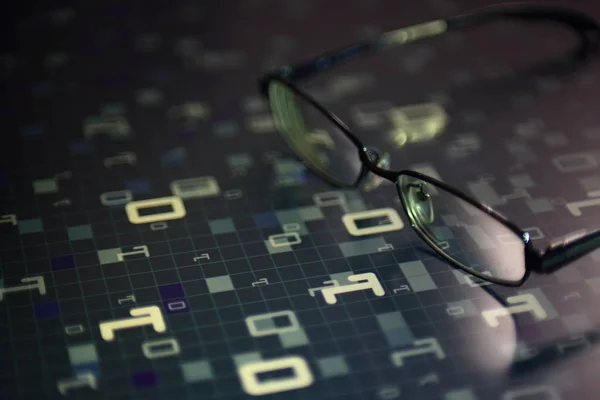 future vision. eyeglasses reflecting light on computer language matrix on LED panel screen. blue block of of light grid. futuristic data analysis and digital living concepts.