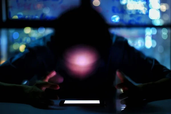 bulanık anonim adam yüz bir masada doğrudan sahte bir beyaz ekran mobil Smartphone bakıyor. şehir siluetinin pencere görünümü ile bir ofis odasında adam bokeh. Modern medya sorunu kavramı. 