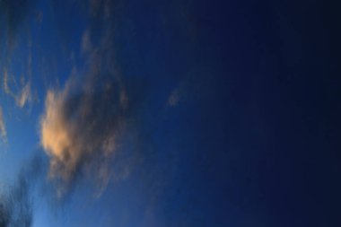 Gökyüzü arka planı. Düşük asılı bulut üzerinde parlayan sıcak günbatımı güneş ışığı ile dikey yönelim gökyüzü. dağınık karanlık yağmur bulutu büyük beyaz bulut çevrili.