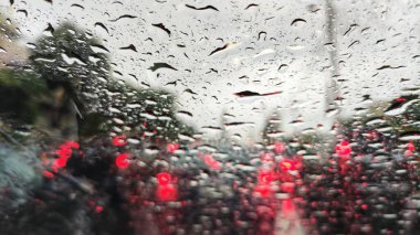 Fırtınaya yakalandım. Araba ön camı fırtınadan gelen şiddetli yağmur suyuyla su sıçratıyor. Yoğun trafik sıkışıklığı ve her yönden kırmızı stop lambaları. Bangkok 'un sorunlu caddesi