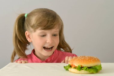 küçük kız baktı ve bir hamburger burnunu çekmek.