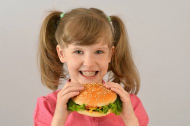 Sevimli küçük kız bir hamburger yemek