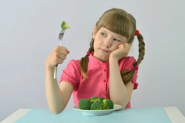little girl (child, kid) does not want to eat broccoli