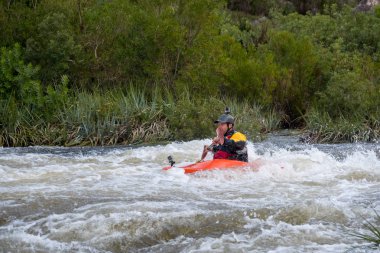 Bazı beyaz su rapids Du Toits Kloof yakınındaki Cape Town Güney Afrika nehir üzerinde aracılığıyla doldurma turuncu bir kayık içinde bir kanocu görüntüsünü
