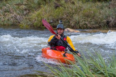 Bazı beyaz su rapids Du Toits Kloof yakınındaki Cape Town Güney Afrika nehir üzerinde aracılığıyla doldurma turuncu bir kayık içinde bir kanocu görüntüsünü