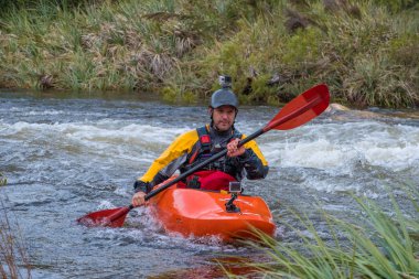 Bazı beyaz su rapids Du Toits Kloof yakınındaki Cape Town Güney Afrika nehir üzerinde aracılığıyla doldurma turuncu bir kayık içinde bir kanocu görüntüsünü
