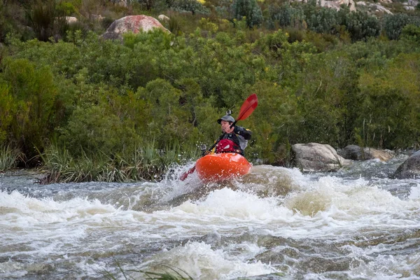 Bazı beyaz su rapids Du Toits Kloof yakınındaki Cape Town Güney Afrika nehir üzerinde aracılığıyla doldurma turuncu bir kayık içinde bir kanocu görüntüsünü
