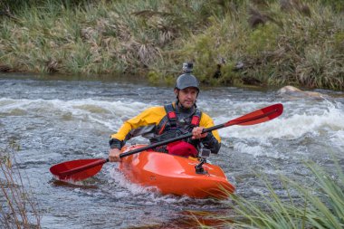Bazı beyaz su rapids Du Toits Kloof yakınındaki Cape Town Güney Afrika nehir üzerinde aracılığıyla doldurma turuncu bir kayık içinde bir kanocu görüntüsünü