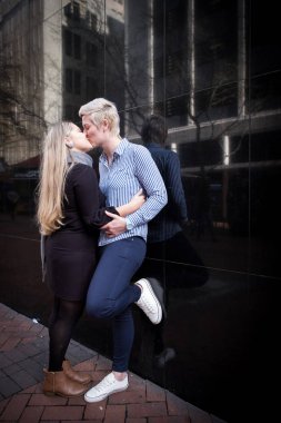 iki lezbiyen gay kadın yirmili bir şehir peyzaj Cape Town, Güney Afrika için siyah bir duvara kucaklamak