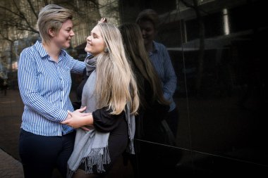 iki lezbiyen gay kadın yirmili bir şehir peyzaj Cape Town, Güney Afrika için siyah bir duvara kucaklamak