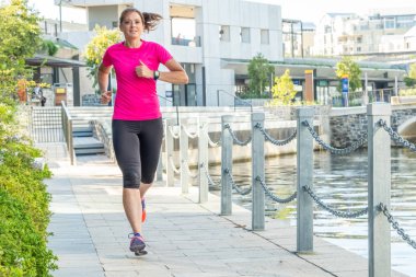 Otuz kadın atletik giyim de cape town, Güney Afrika genel bir parkta bir kanal boyunca çalışan bir şey