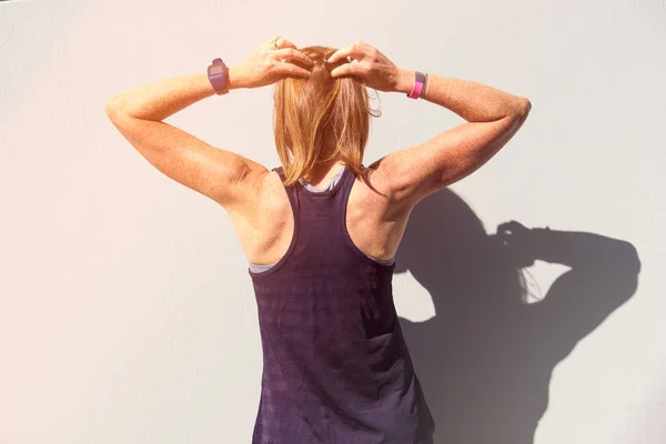 Female fitness athlete tieing her hair — Stock Photo, Image