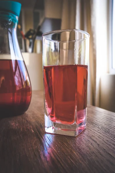 Glass and jug of herbal fruit tea — Stock Photo, Image