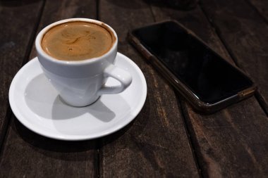 beyaz bir fincan ve akıllı telefon çift espresson