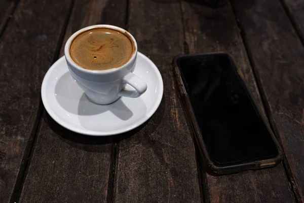 Double espresson in a white cup and smart phone — Stock Photo, Image