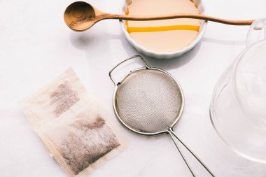 Çay poşetleri ve ekipmanlar parlak bir arkaplanda çay hazırlamak için kullanılır.