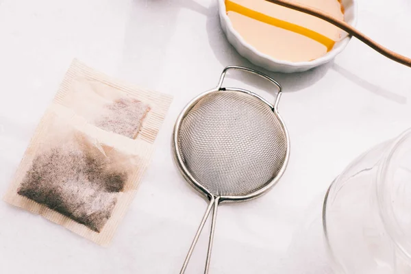 Çay poşetleri ve ekipmanlar parlak bir arkaplanda çay hazırlamak için kullanılır.