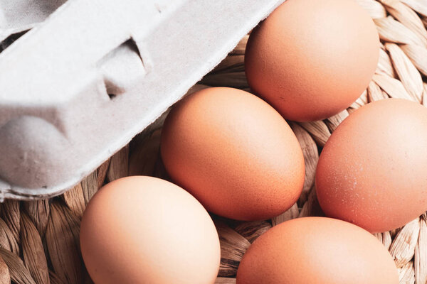 eggs and an egg box on a woven mat background