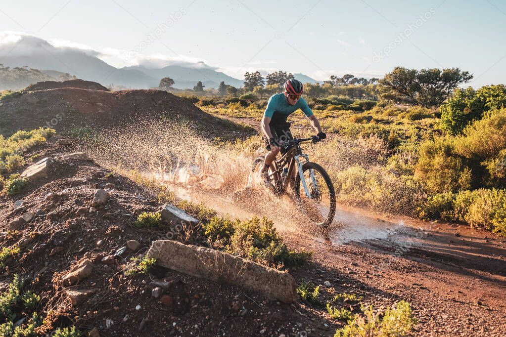 mountain biker cycling on a dirt track during autumn, fall and winter seasons