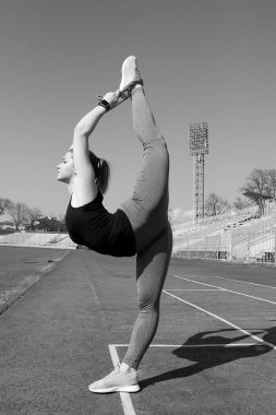 Genç güzel sarışın spor kız koşu parkuru, Stadyumu üzerinde yapıyor. Tribün arka plan üzerinde. Yaz kadın fitness aktivitesi tarih Pzr