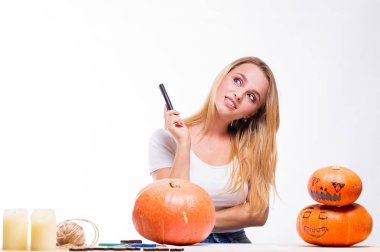 Cadılar Bayramı kavramı, mum ve ip, tatil için hazırlanıyor kabak ile masada oturan kız nasıl fener, komik ve ürkütücü Jack için düşünüyorum. Ya parani ya canini geleneği