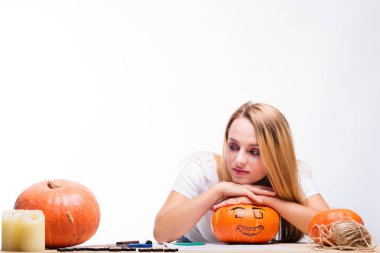 Cadılar Bayramı kavramı, mum ve ip, tatil için hazırlanıyor kabak ile masada oturan kız nasıl fener, komik ve ürkütücü Jack için düşünüyorum. Ya parani ya canini geleneği