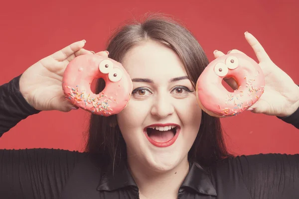 Model plus size with sweet donuts, happy girl smiling holding in