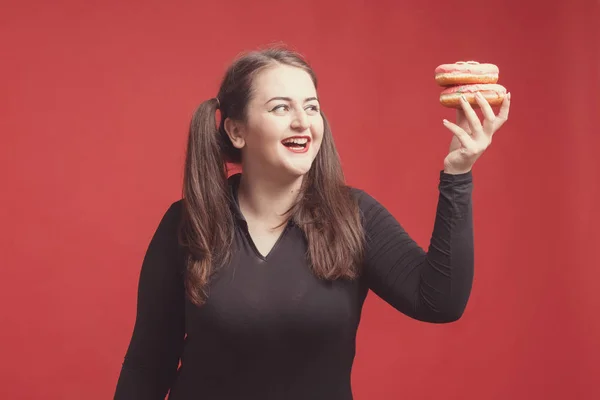 Model plus size with sweet donut, happy girl smiling holding in