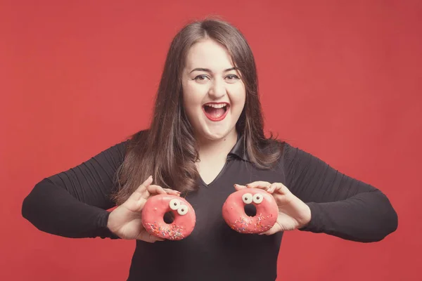 Model plus size with sweet donuts, happy girl smiling holding in