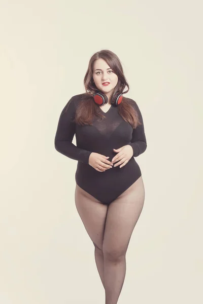 Model plus size with sweet donut, happy girl posing with headpho — Stock Photo, Image