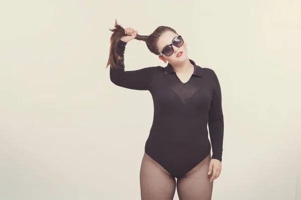 Modell plus size mit süßem Donut, glückliches Mädchen posiert mit Sonnenbrille — Stockfoto