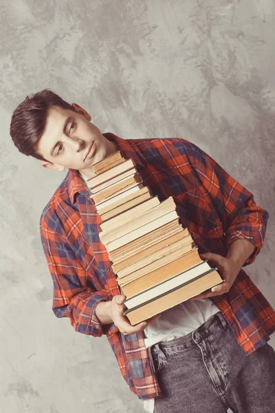 Jovem estudante segurar muitos livros. O tipo quer aprender, ter educa — Fotografia de Stock
