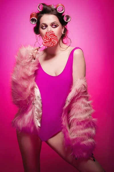 Chica descarada con corazón de caramelo posando sobre fondo rosa en el cuerpo a — Foto de Stock