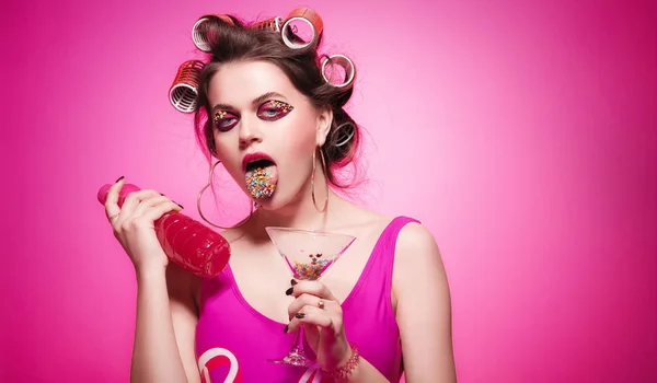 Freche Mädchen mit Flasche, rosa Wasser, Süßigkeiten auf Zunge und Glas — Stockfoto