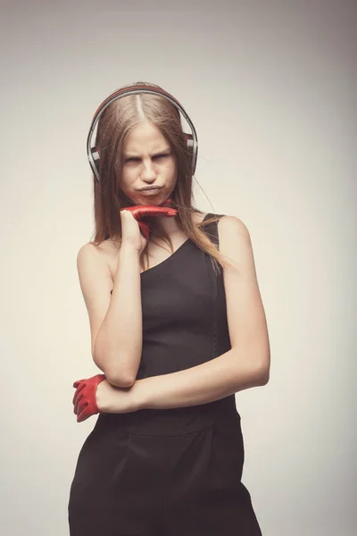 Moda chica bonita escuchando música con auriculares, usando rojo —  Fotos de Stock