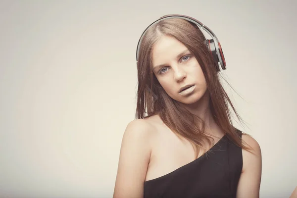 Moda chica bonita escuchando música con auriculares, usando rojo — Foto de Stock