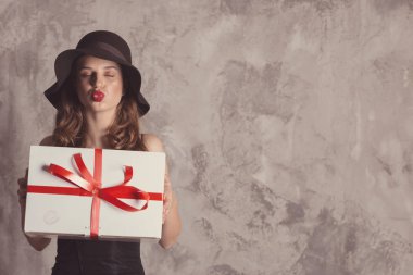 Siyah elbiseli, uzun bacaklı, kendine güvenen şık bir kadın.