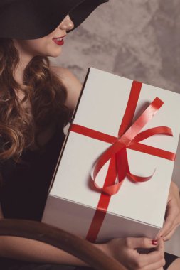 Siyah elbiseli, uzun bacaklı, kendine güvenen şık bir kadın.