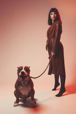 Kahverengi deri ceketli çekici genç bir kadın.