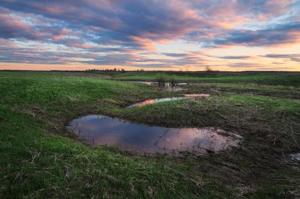 Reflection of a beautiful sunset in a spring pools — Stock Photo, Image