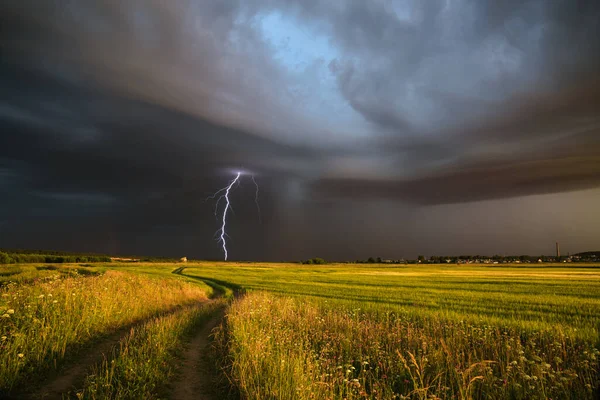 Landstraße Inmitten Eines Feldes Und Ein Blitz Dramatischen Himmel Hintergrund Stockfoto